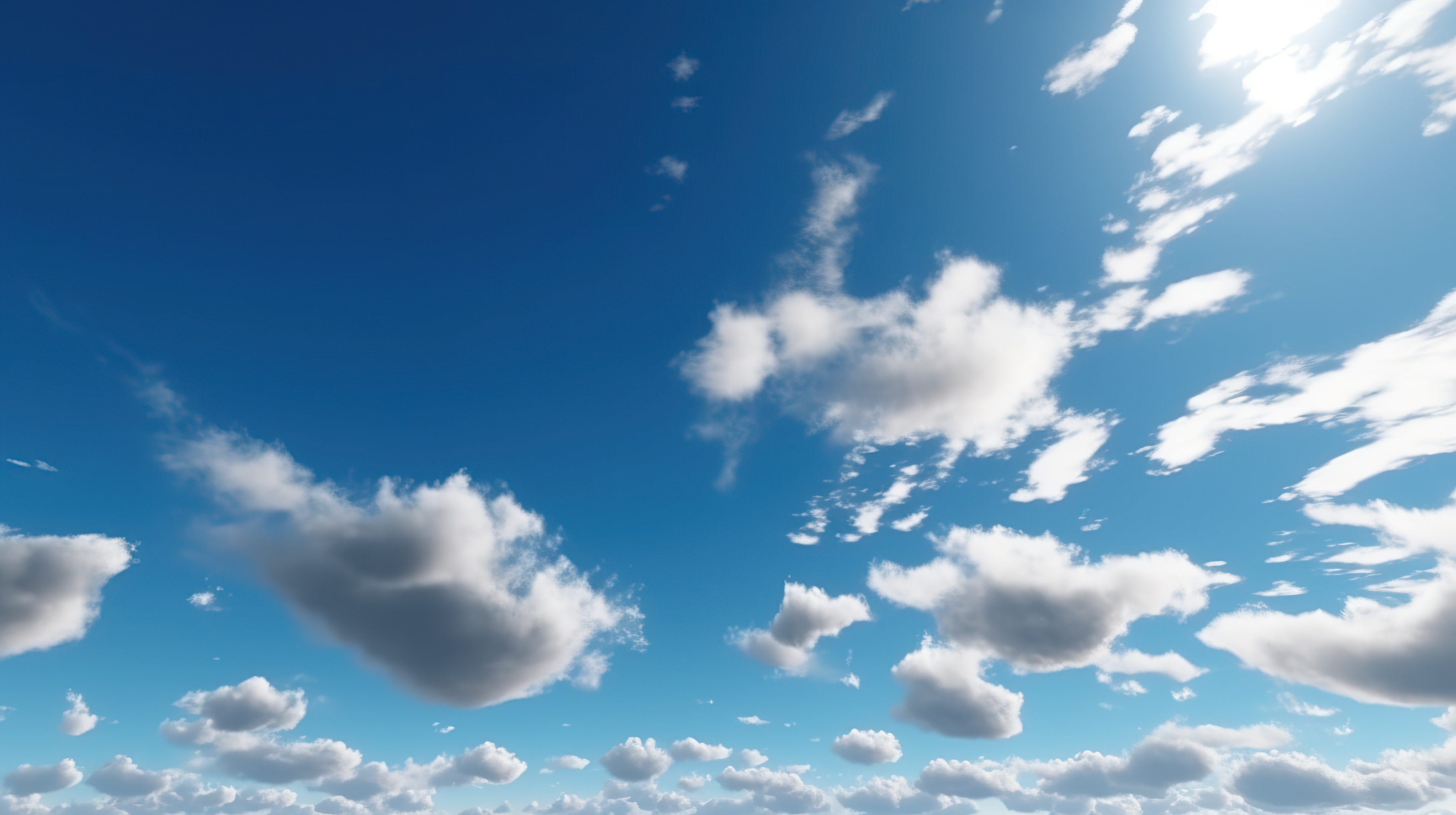 A clear blue sky with fluffy white clouds scattered throughout