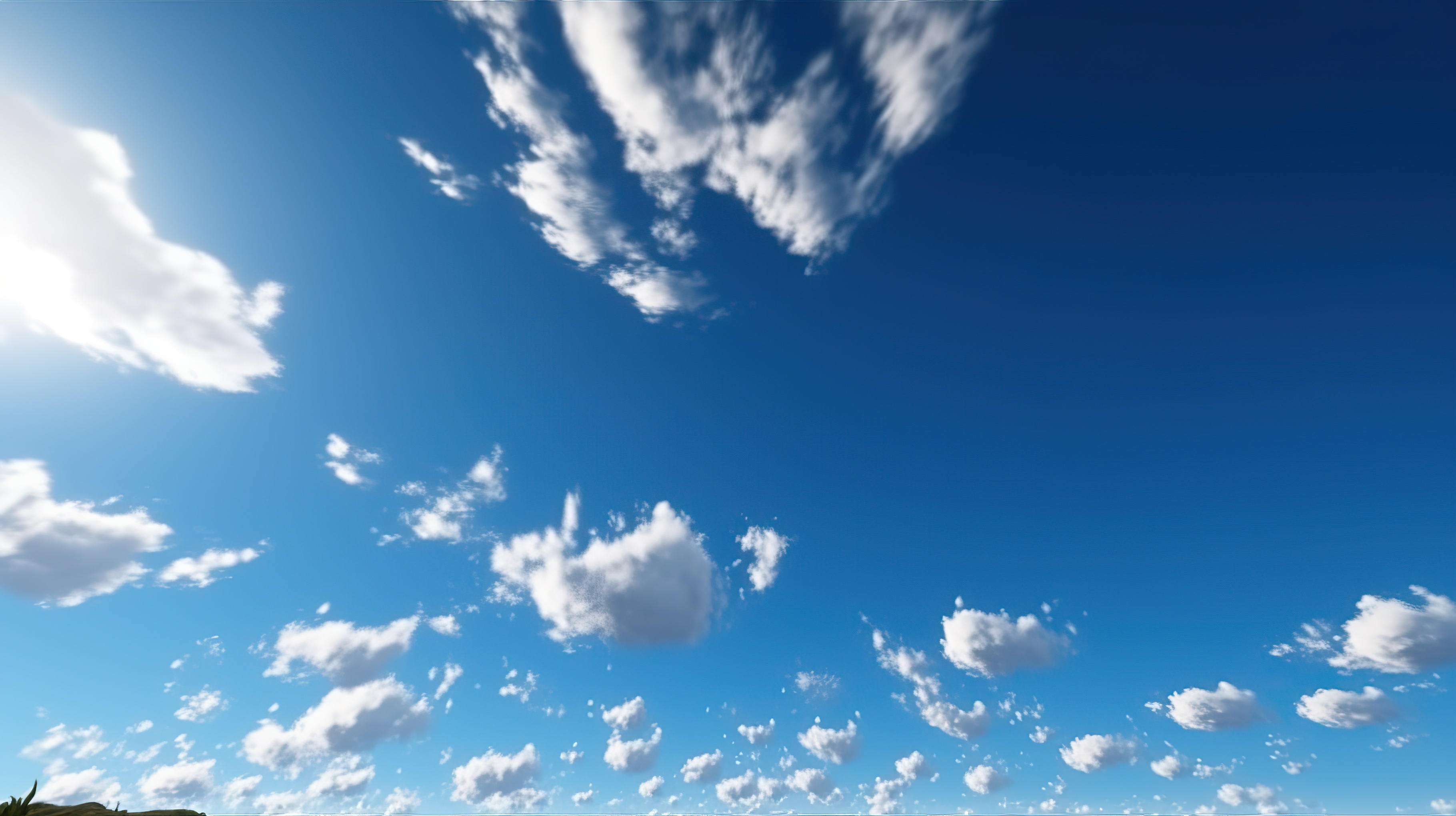 A clear blue sky with fluffy white clouds scattered throughout