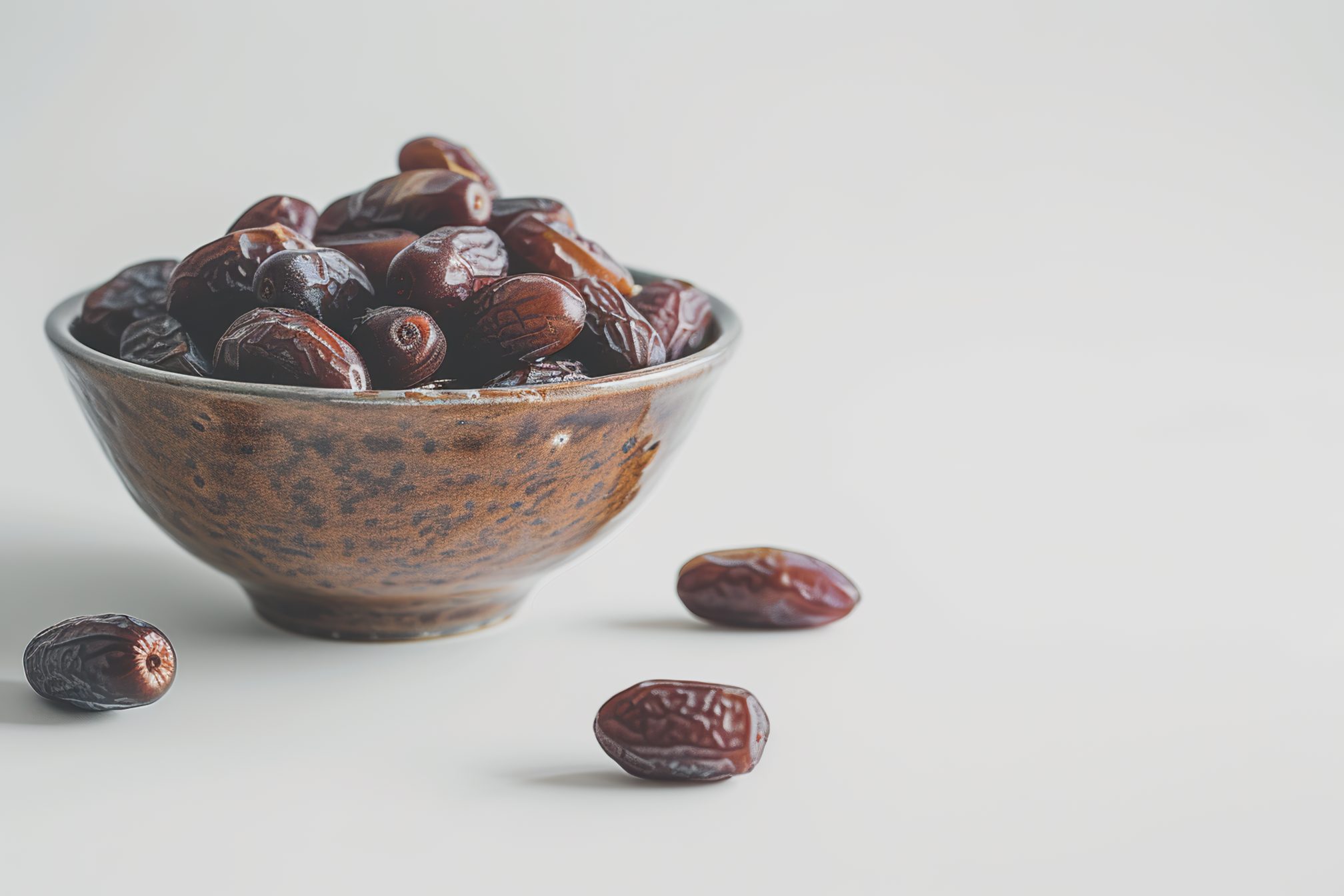 A bowl full of dates on white background