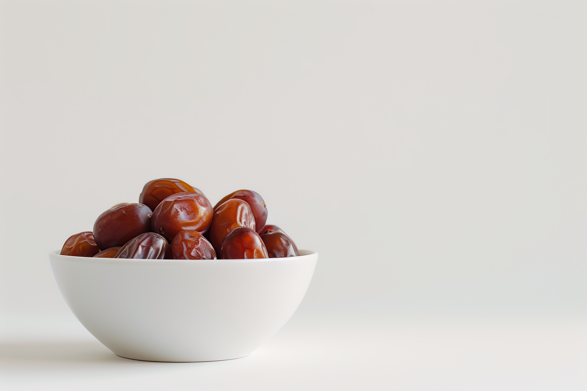 A bowl full of dates on white background