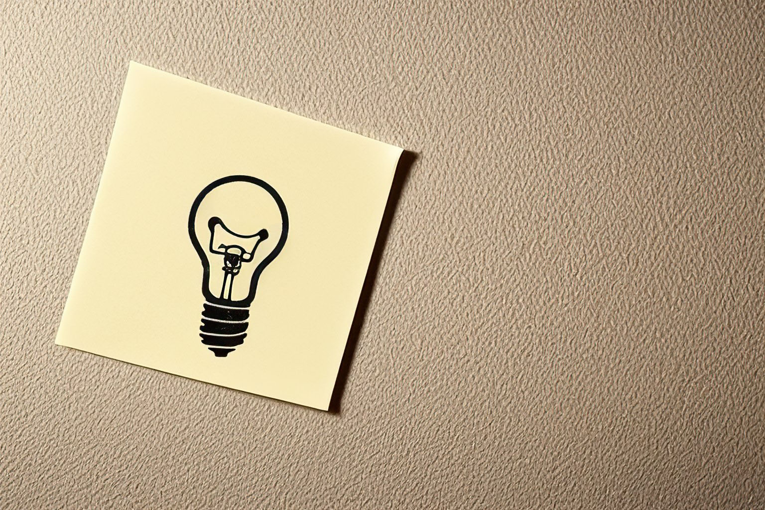 Light bulb idea symbol on yellow sticky note