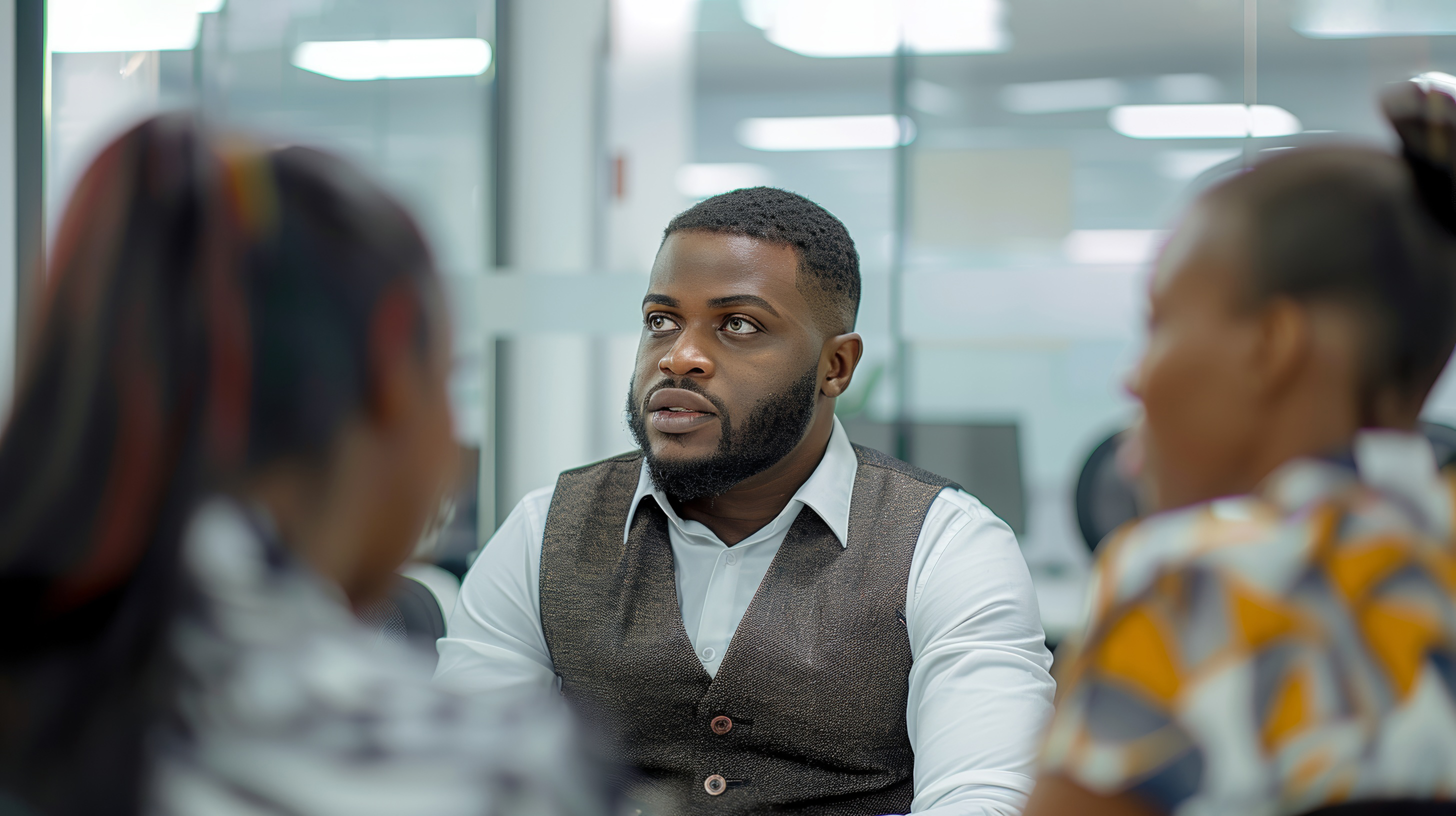 Young African businessman talking with a group of coworkers during a meeting together, Generative AI